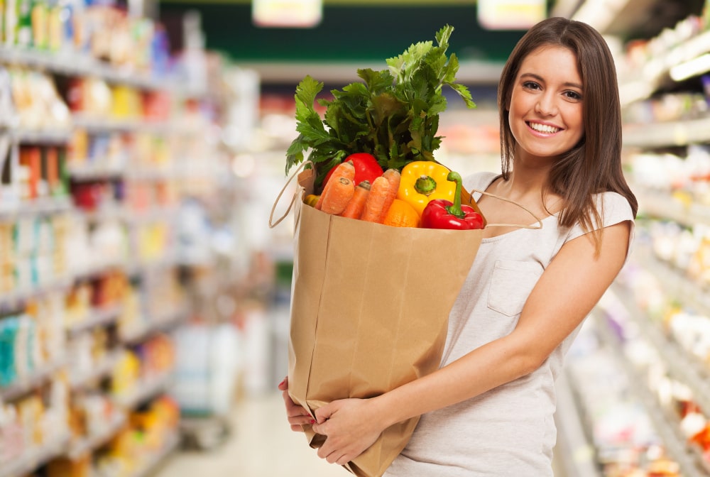 healthy-positive-happy-woman-holding-paper-shopping-bag-full-fruit-vegetables-min.